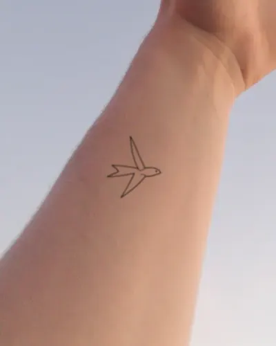 Fine line swallow tattoo on a wrist, preview